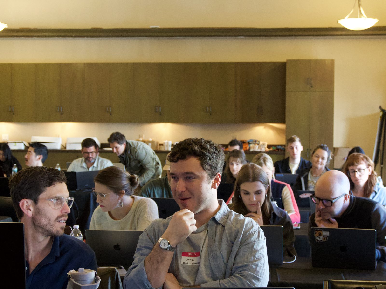 Participants building on their laptops at long tables