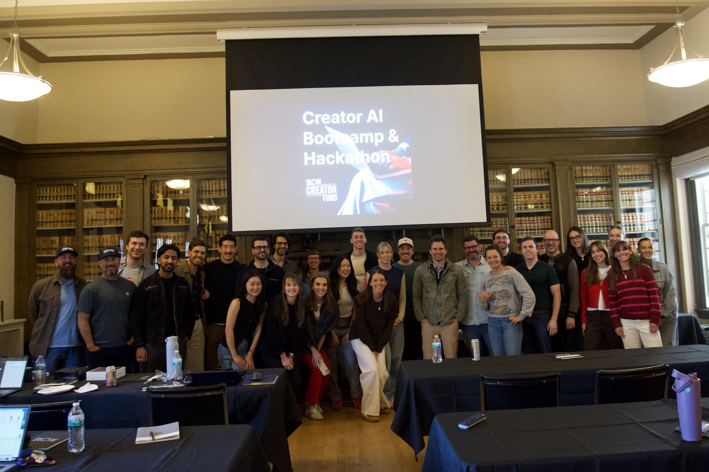 Hackathon participants and the Tanooki Labs team pose together in front of the presentation screen